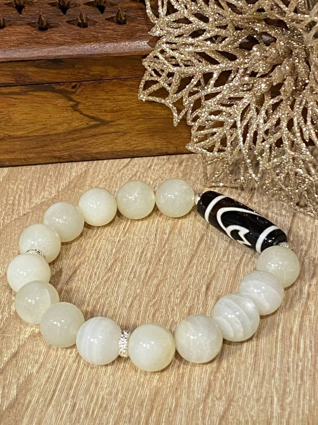 Бусина Дзи "Лотос" в браслете из лунного камня Бусина Дзи "Лотос" в браслете из лунного камня