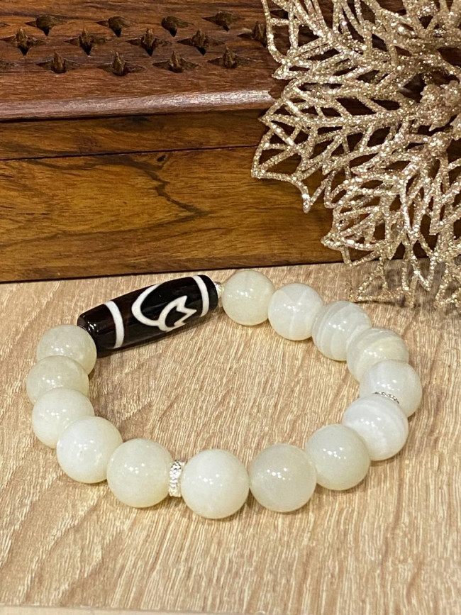 Бусина Дзи "Лотос" в браслете из лунного камня Бусина Дзи "Лотос" в браслете из лунного камня