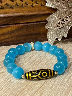 Бусина Дзи 6 глаз золотая в браслете из голубого кошачьего глаза 12 мм Бусина Дзи 6 глаз золотая в браслете из голубого кошачьего глаза 12 мм